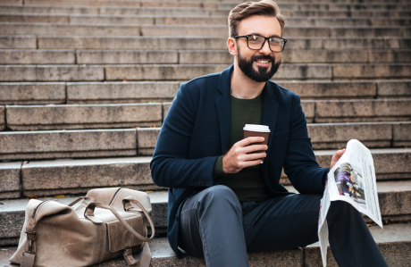 Happy young bearded man sitting